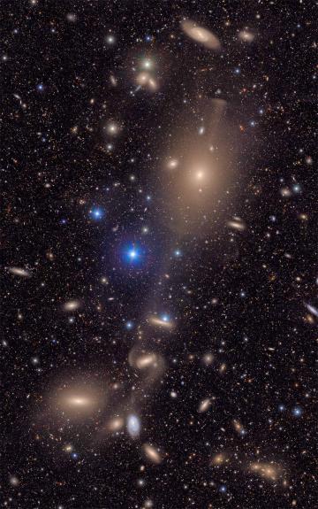 A deep-space image showing a dense field of galaxies and stars scattered across a dark sky. 