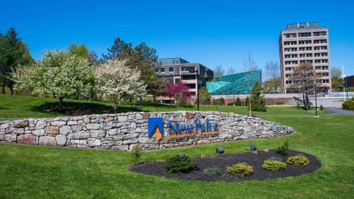Campus shot of SUNY New Paltz with green grass, buildings and a blue sky.