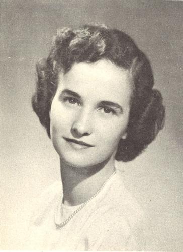 A black and white studio portrait of a young woman from the mid-20th century, wearing a subtle pearl necklace and a light-colored top. She has dark, curly hair styled in soft waves.