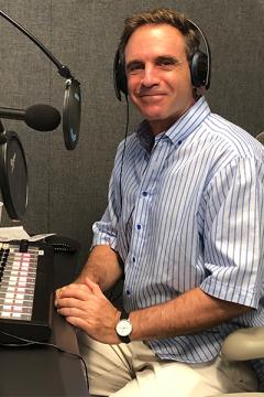 Journalist and podcaster Eric Marcus ’80 seated in front of a microphone