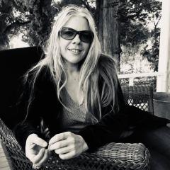 black-and-white portrait of art critic Shana Nys Dambrot '93 wearing sunglasses