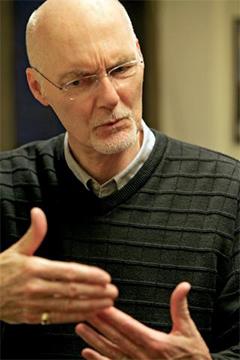 Professor Cornelius gestures with his hands while explaining something.