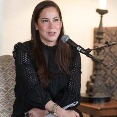 Karin Tanabe sitting in a chair and speaking into a microphone.