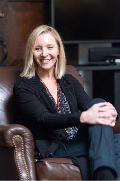 Smiling person sitting in an armchair.