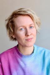 Katie Gemmill wearing a pink and blue shirt against a light background.
