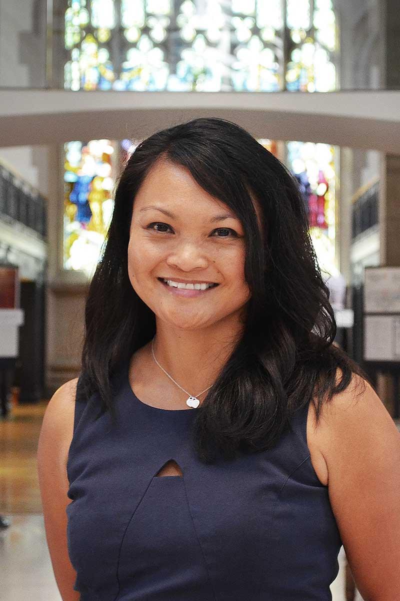 A headshot of Dr. Michele Tugade, a person with long black hair and a blue dress.