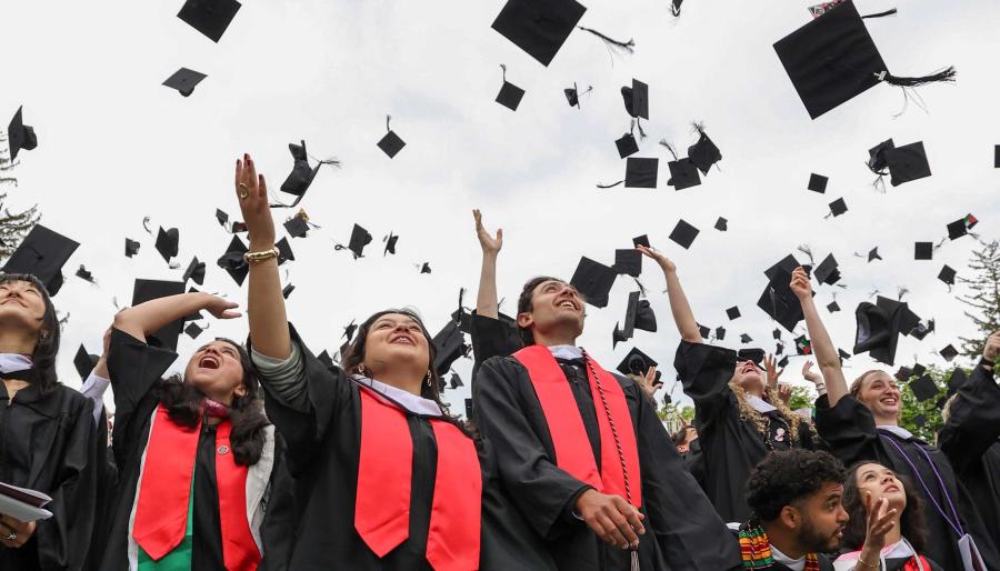 Jubilant graduates throw their mortar boards in the air.