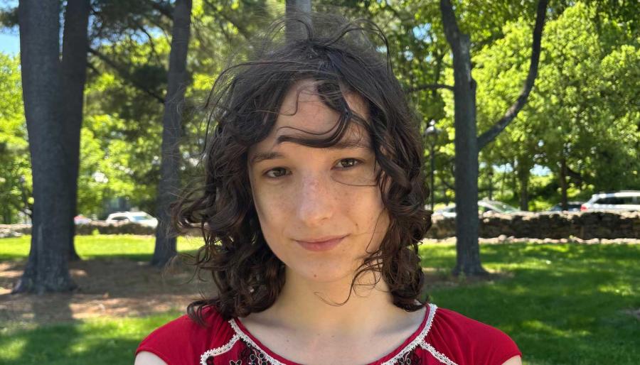 Headshot of a smiling person outdoors.