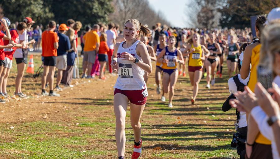 A runner races ahead of the pack on an outdoor course.
