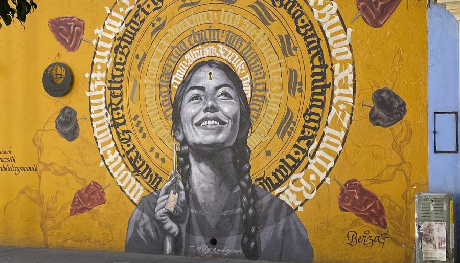 A golden colored mural depicting a young smiling woman.