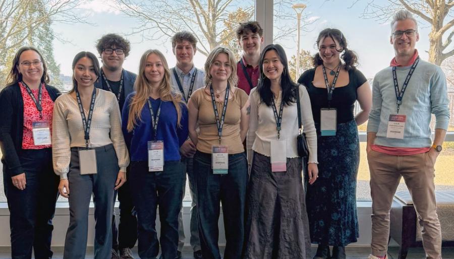 Group of people standing and smiling at a conference.
