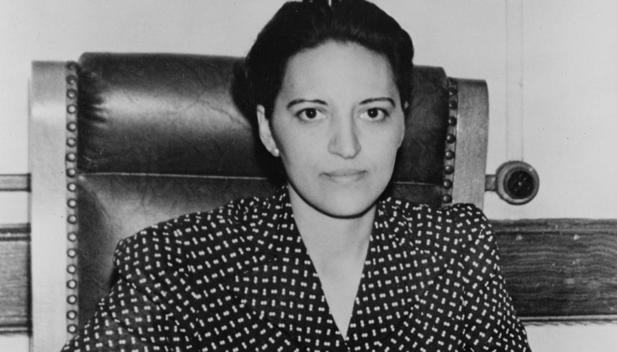 1940s image of a woman sitting at executive desk.