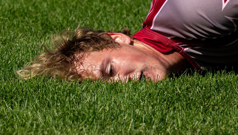 A rugby player lying face first in the grass