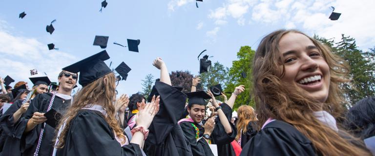 2022 Commencement students throwing their caps in the air