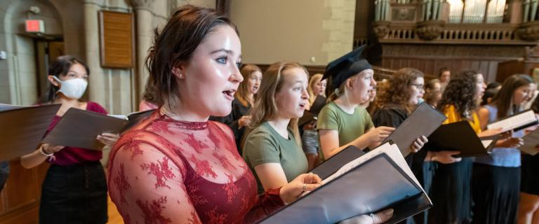 Vassar College Chorus holding music books singing at Convocation.