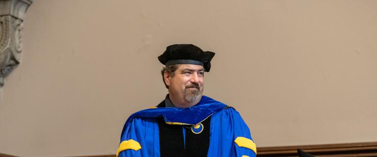 José Perillán wearing black cap and blue gown with black stole at Vassar College Convocation.