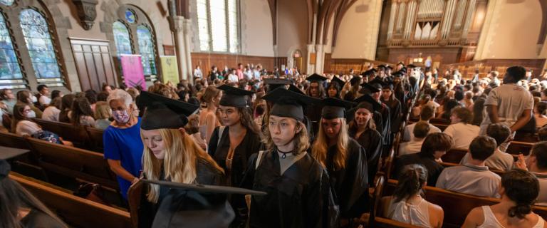 Students wearing black caps and gowns in Recessional at the Chapel during Vassar College Convocation.