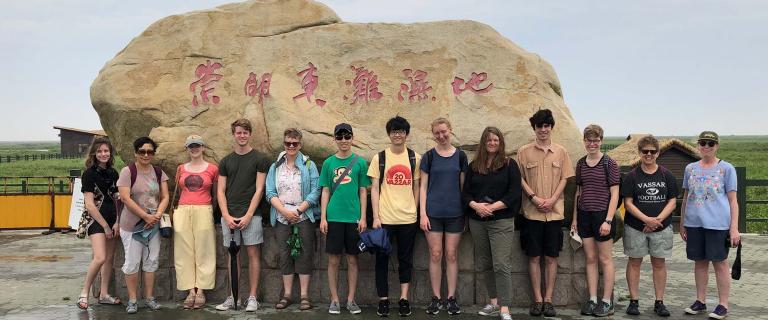 Group photo of Asian Studies trip in front of a big rock