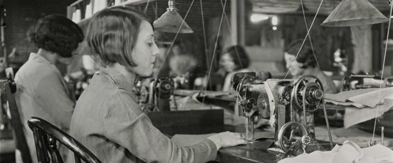 Black and white photo of person at a sewing machine