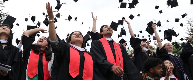 Jubilant graduates throw their mortar boards in the air.