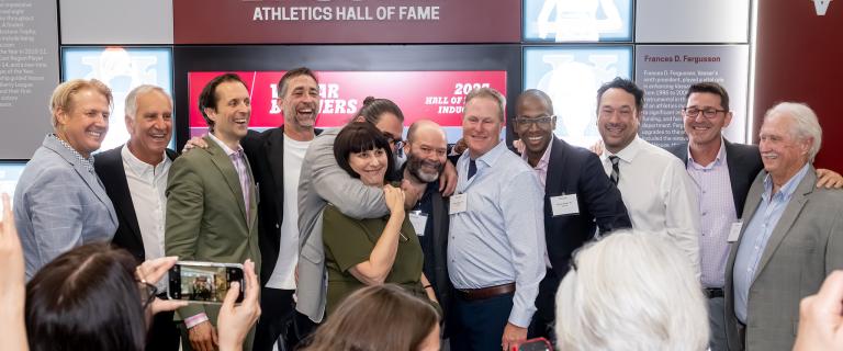 A group standing in front of a display, celebrating.
