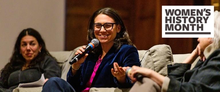 Photo from event, focussed on a speaker in the center of the 3-person panel.