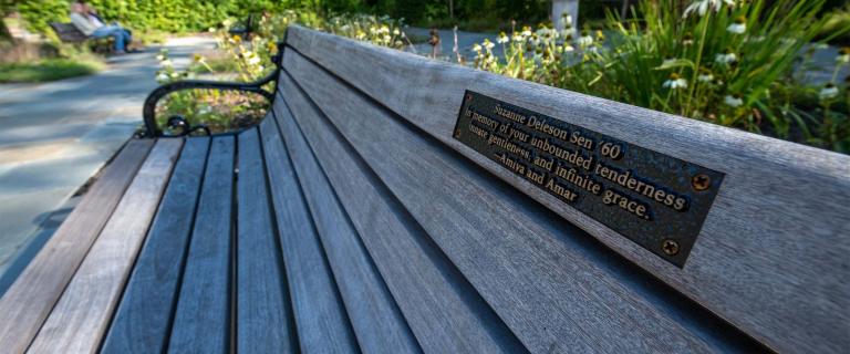 Bench in Shakespeare Garden with plaque reading: Suzanne Deleson Sen '60. In memory of your unbounded tenderness, innate gentleness, and infinite grace. Anna and Amar.