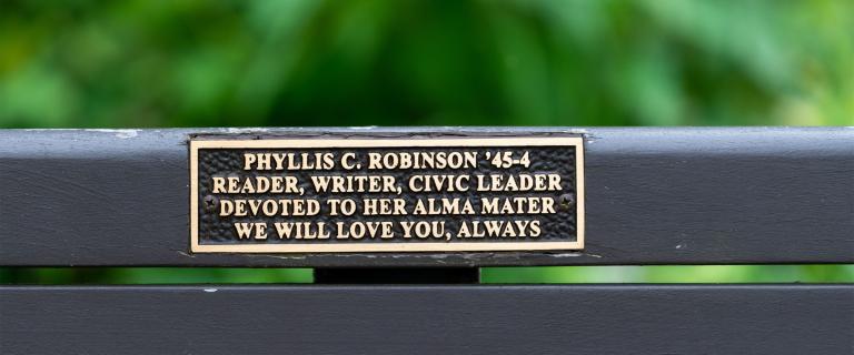 Close up of plaque on bench reading: Phyllis C. Robinson '45-4. Reader, writer, civic leader devoted to her alma mater. We will love you, always.