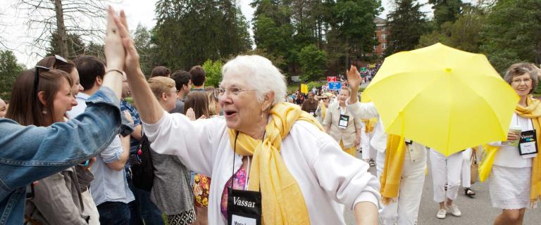 A smiling parade participant "high-fiving" a spectator along the way.
