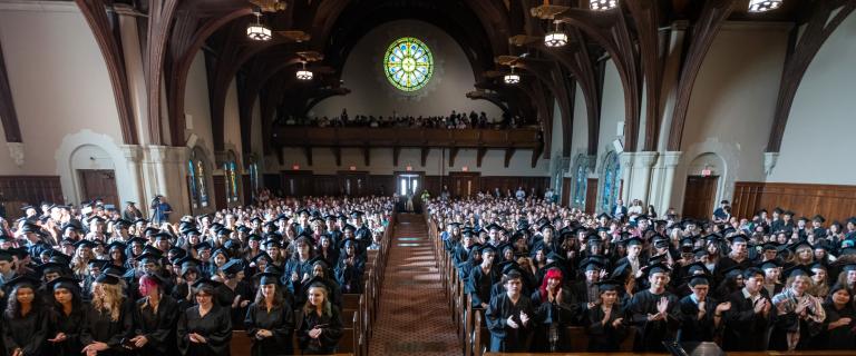 Seated convocation audience in a large hall.