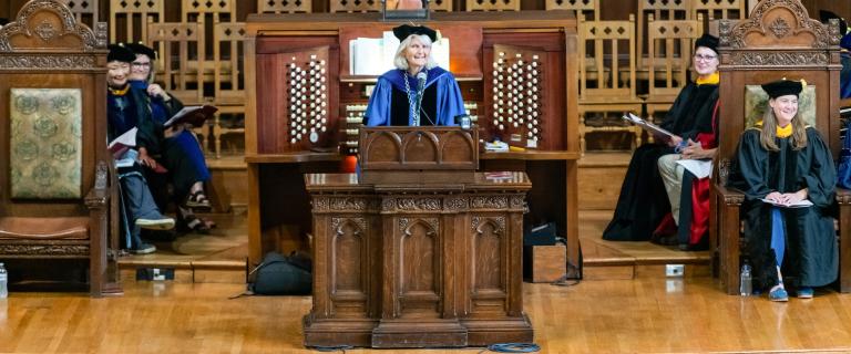 Convocation speaker behind the mic.