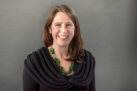 Amanda Culp wearing a black shirt and green necklace strung with multi-sized green circles.