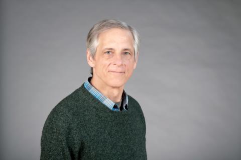 Luke Hunsberger wearing a green sweater over a blue plaid shirt.