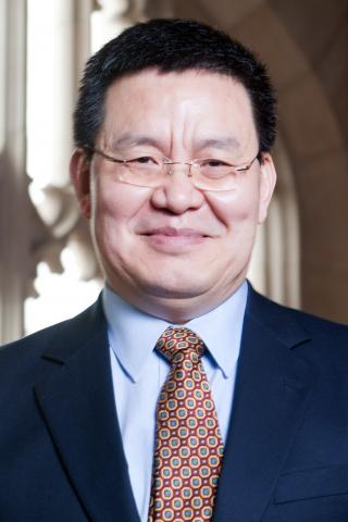 Haoming Liu wearing a blue shirt, navy jacket and red patterned tie. 