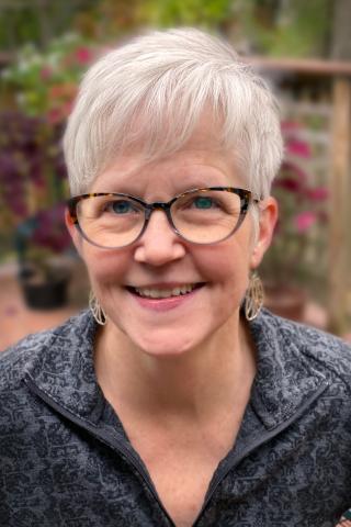 Nancy Jo Pokrywka - Headshot of a woman with grey hair and glasses