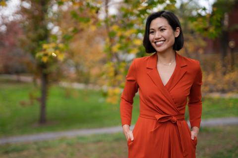 Catherine Tan Portrait standing outside in front of trees in a red dress.