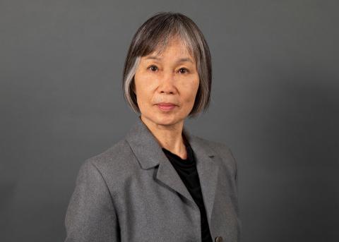Anne Parries wearing a black shirt and grey jacket