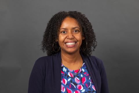 Woman with a blue petal pattern shirt and blue blazer smiling - Pictured: Krystle McLaughlin