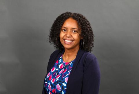 Woman with a blue petal pattern shirt and blue blazer smiling - Pictured: Krystle McLaughlin