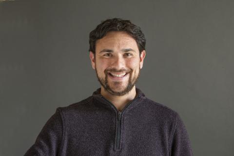 Man with black hair and a beard smiling - Pictured: Payton Small 