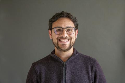 Man with black hair and a beard smiling - Pictured: Payton Small 