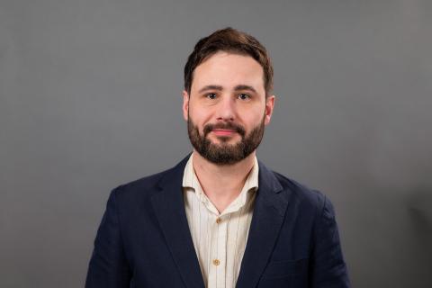 Studio portrait of a person in a suit jacket with no tie.