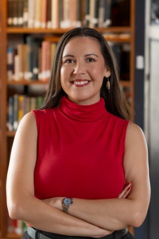 Portrait of a person with library shelves in the background.