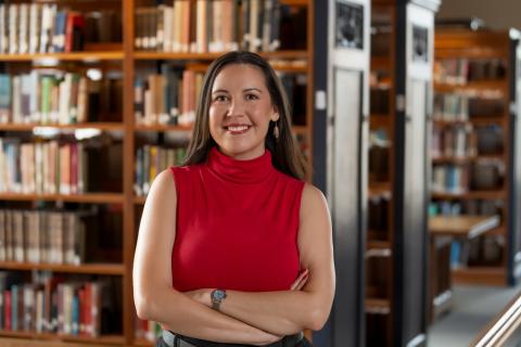 Portrait of a person with library shelves in the background.