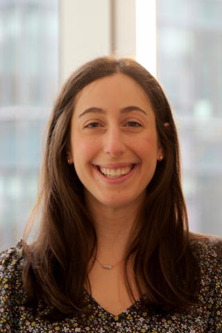 Stephanie Jackvony wearing a black flowered shirt and has long dark hair.  