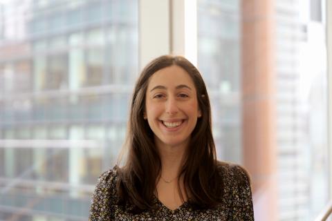 Stephanie Jackvony wearing a black flowered shirt and has long dark hair.  
