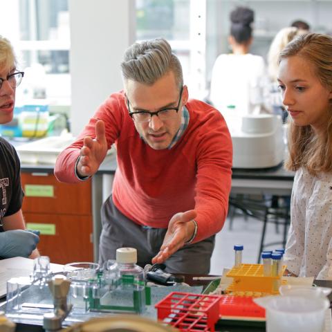 Assistant Professor of Biology and Biochemistry Colin Echeverría working in a class with two students