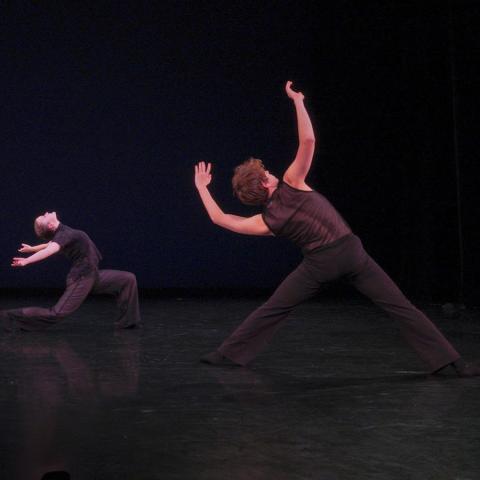 Two dancers dressed in black perform choreography by Kirven Boyd