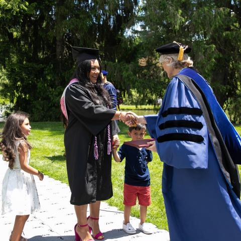 Army vet Tanya Marie Painter, joined by family, about to receive her diploma from Vassar College President Elizabeth H. Bradley at Commencement in 2019.