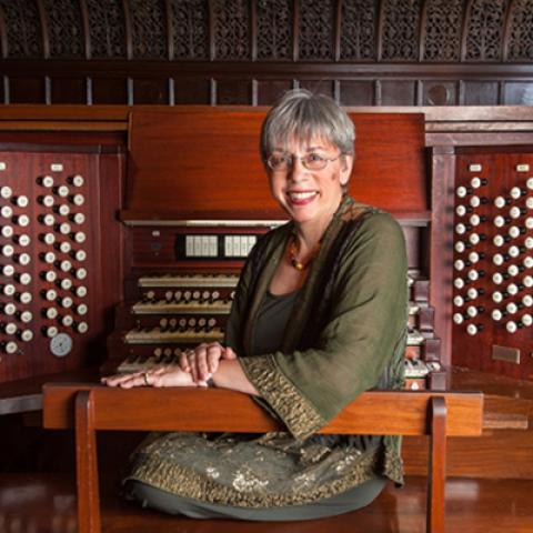 Organist Gail Archer seated by her instrument.